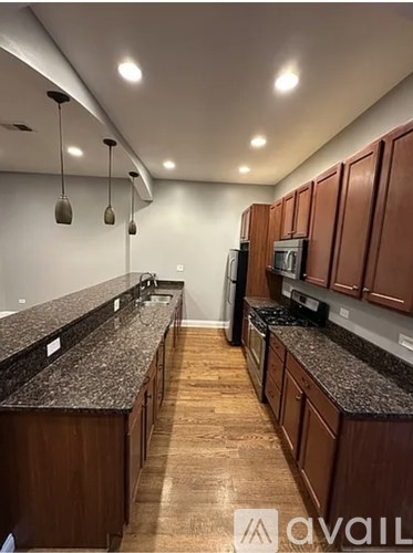 A kitchen with brown cabinets and granite countertops.
