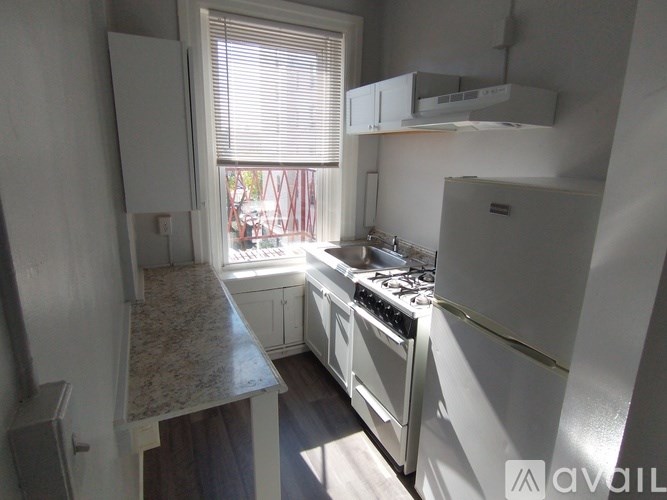 A kitchen with white appliances and a marble countertop.