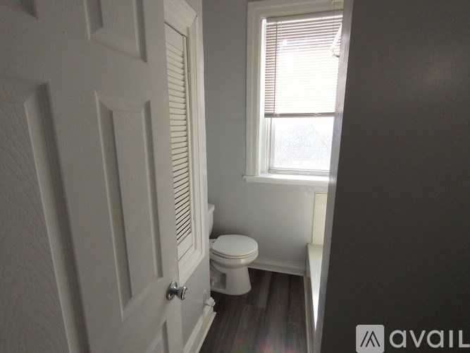 A small bathroom with a toilet and a window.