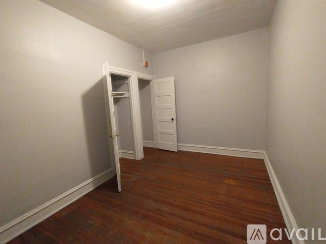 A room with wooden floors and two windows.