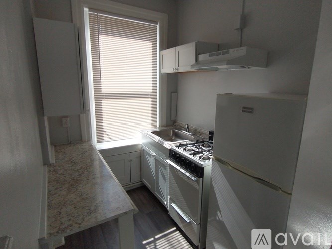 A kitchen with a stove top oven and a refrigerator.
