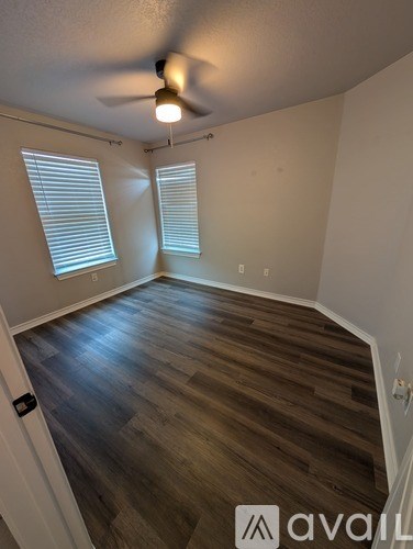 A room with wooden flooring and a ceiling fan.