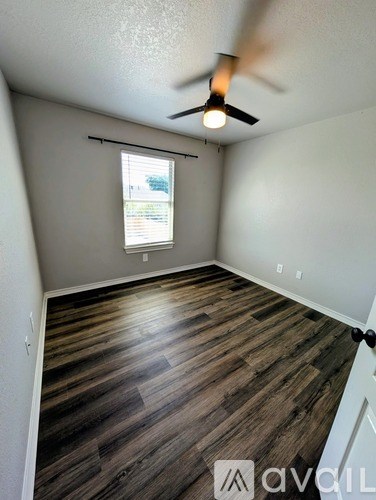 A room with wooden flooring and a ceiling fan.