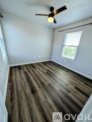 A room with wooden flooring and a ceiling fan.