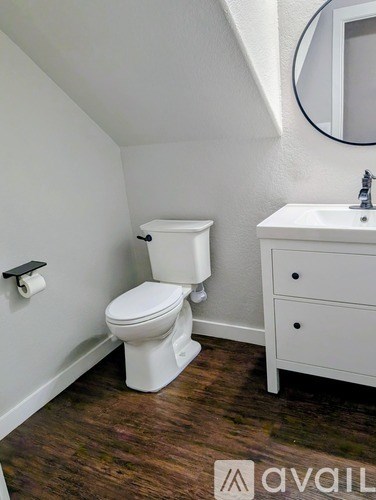 A white toilet and sink in a small bathroom.