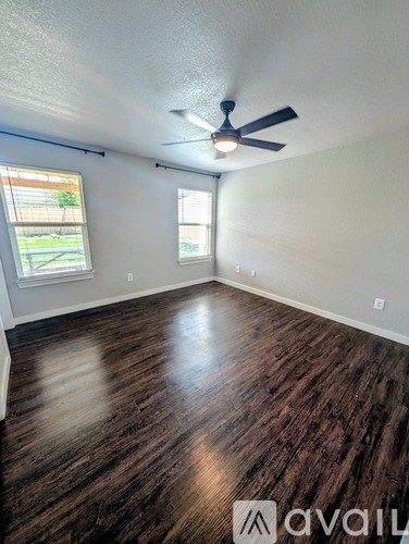 A room with wooden flooring and a ceiling fan.
