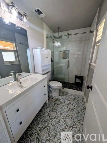 A bathroom with a sink, toilet, and shower.