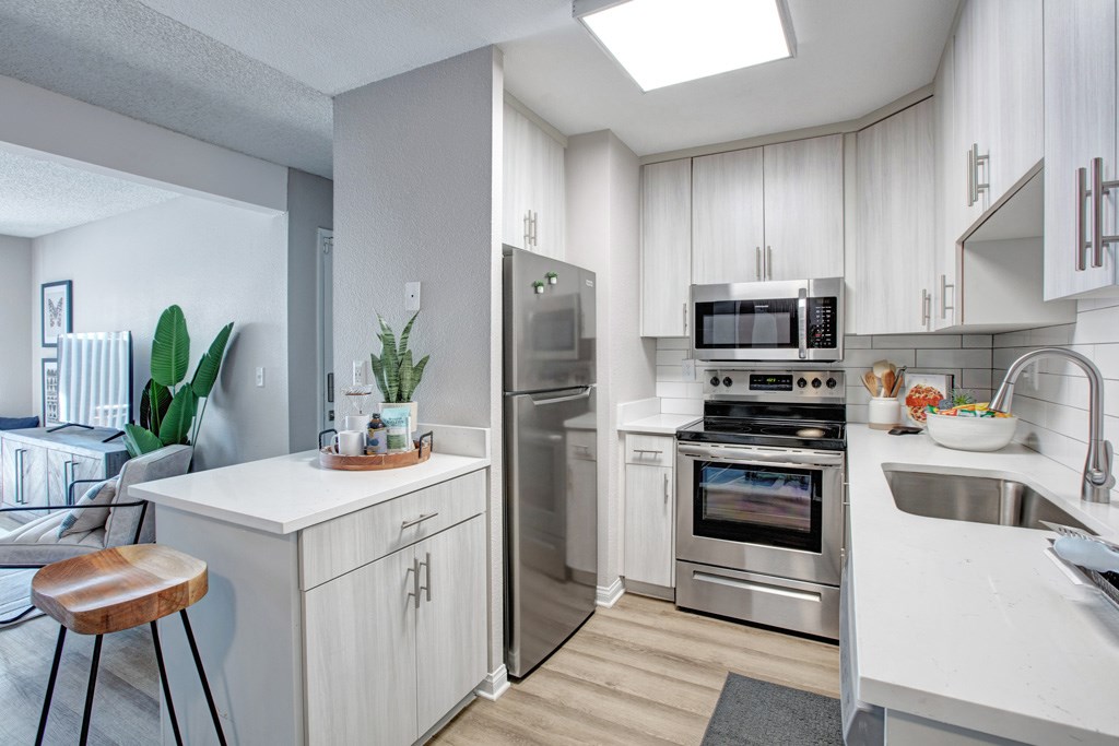 A modern kitchen with stainless steel appliances and white cabinetry.
