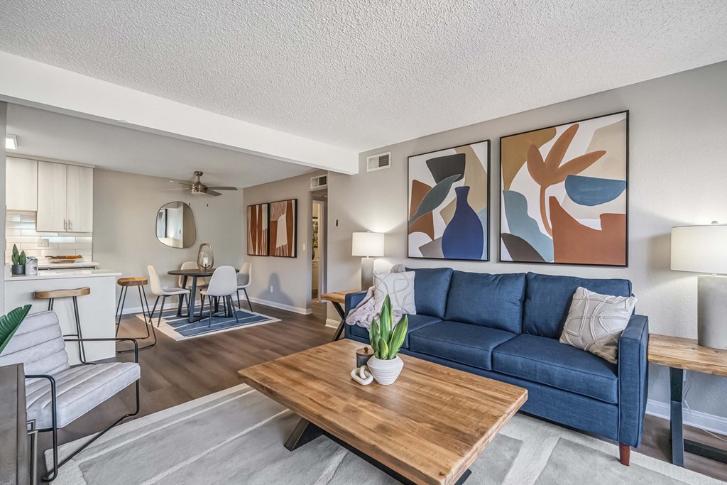 A living room with a blue couch and a wooden coffee table.