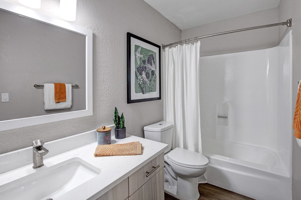 A bathroom with a white toilet, sink, and bathtub.
