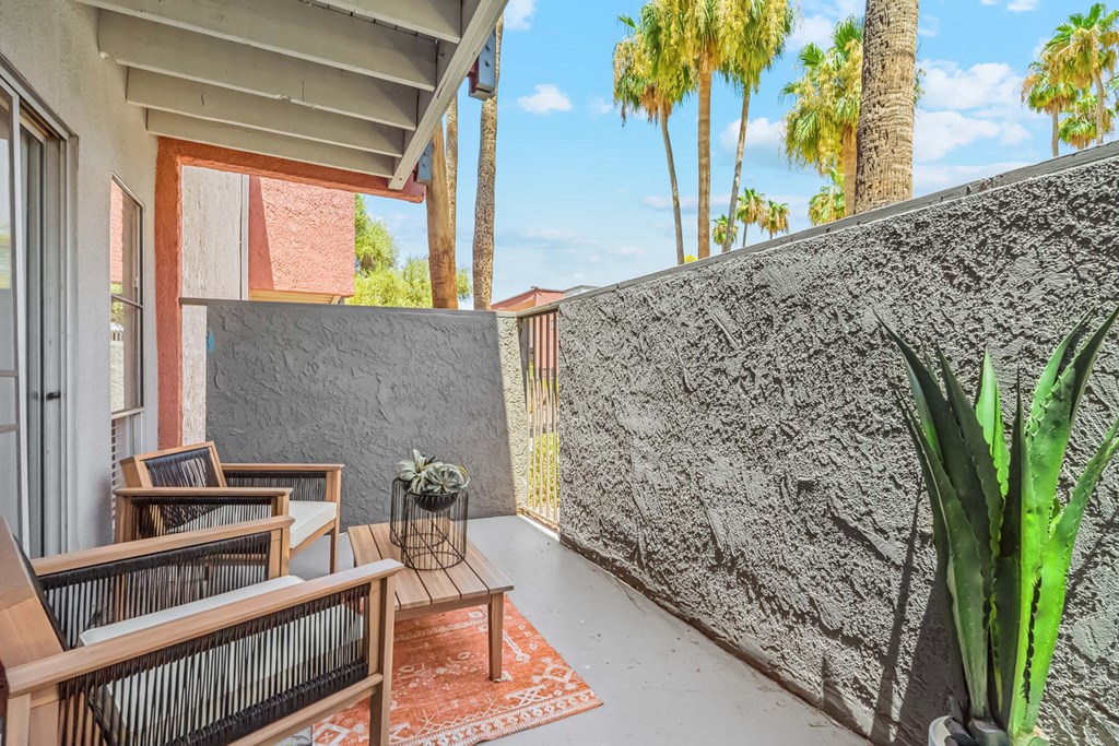A patio with a couch, table, and plants.