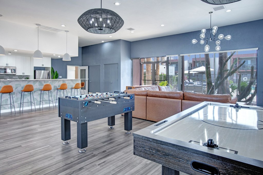 A pool table in a room with a view of the outdoors.