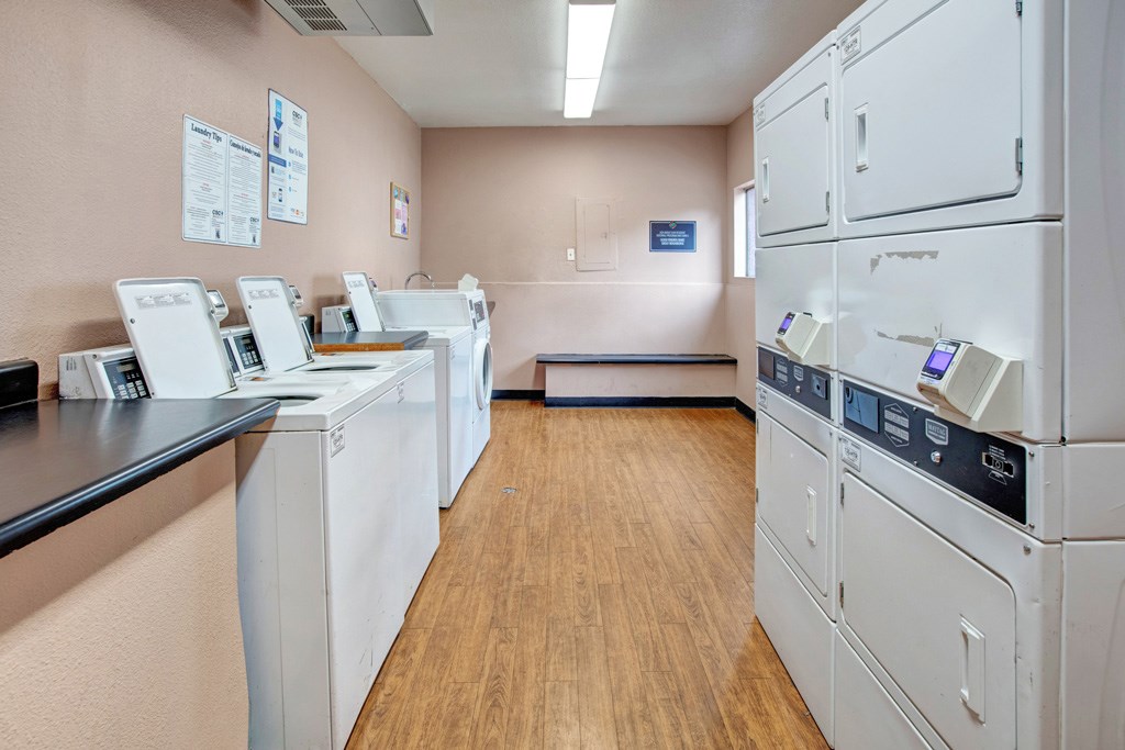 A laundromat with washers and dryers lined up.