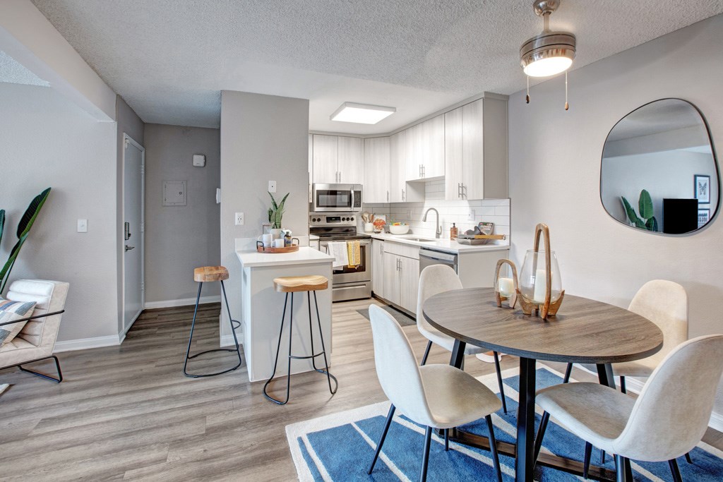 A modern kitchen with a dining table and chairs.