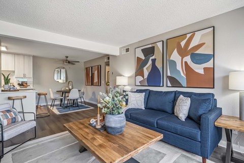 A living room with a blue couch and a wooden coffee table.