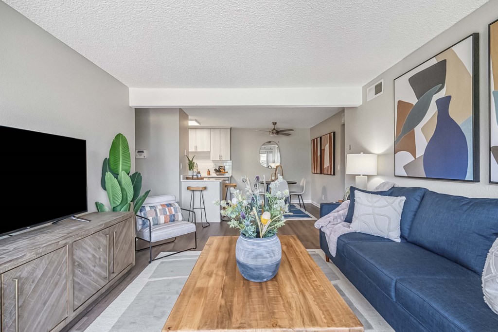 A living room with a blue couch and a wooden coffee table.