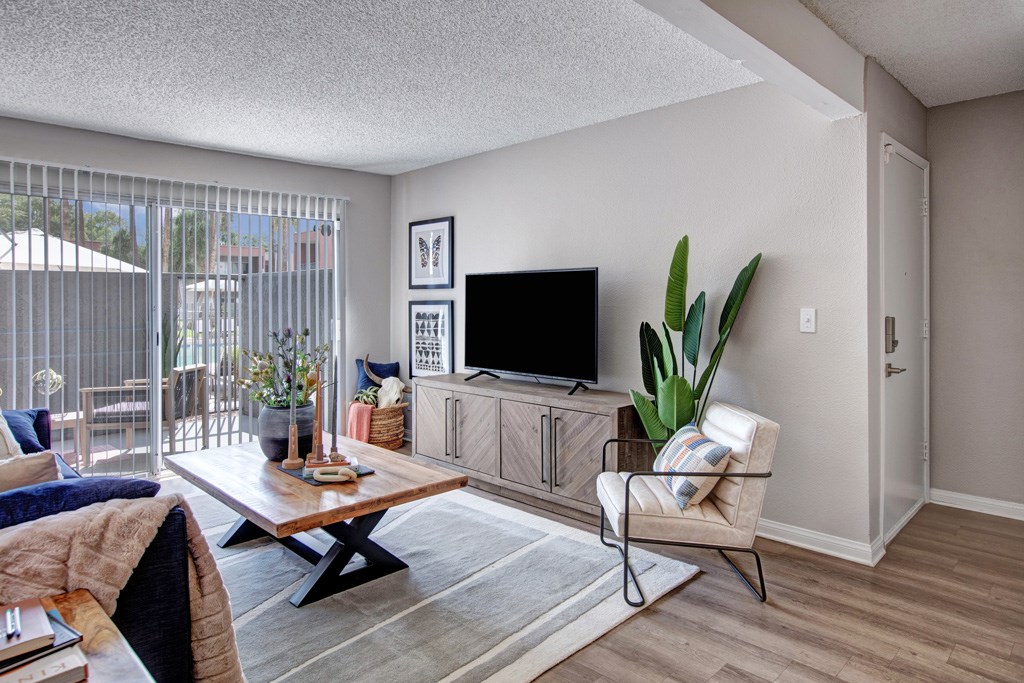 A living room with a television, a chair, and a table.