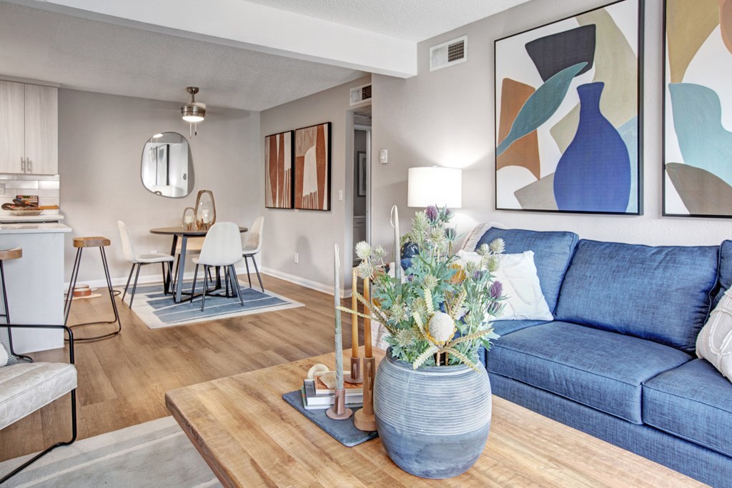 A living room with a blue couch and a wooden coffee table.