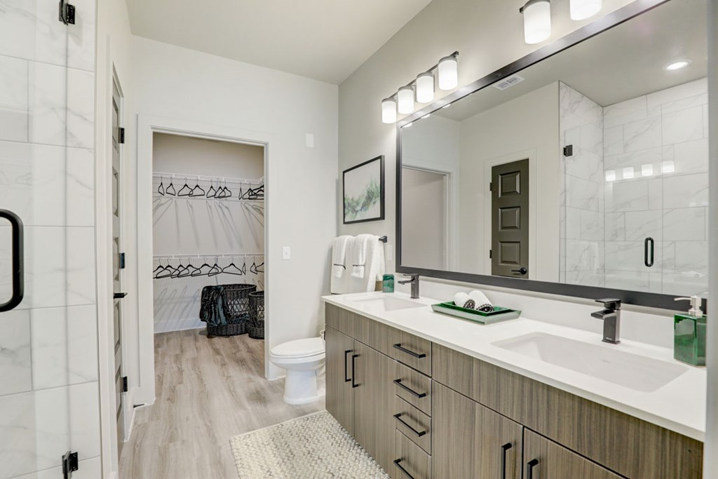 A bathroom with a marble tile shower and a white toilet.