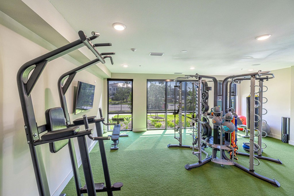 A gym with a variety of equipment including a treadmill, a stationary bike, and a weight machine.