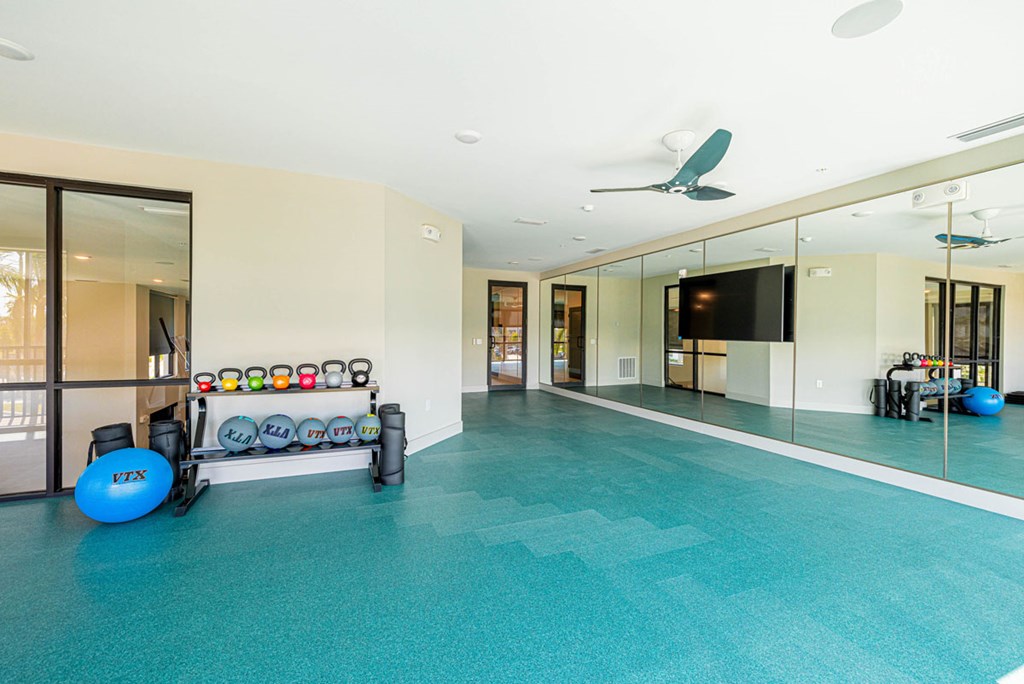 A room with a blue exercise ball and a mirrored wall.