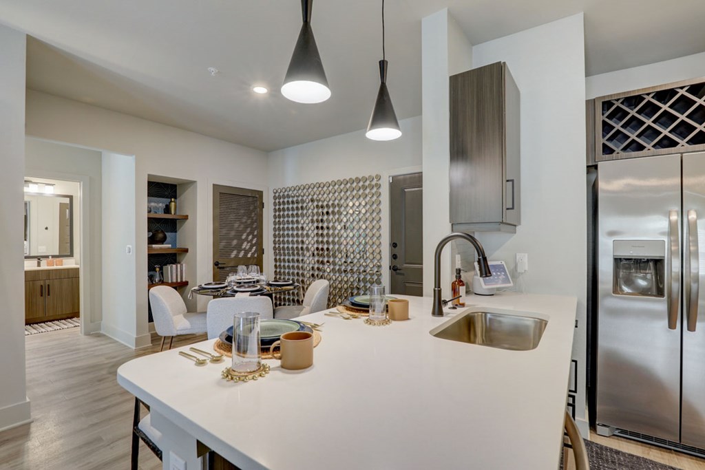 A modern kitchen with a white island and stainless steel appliances.