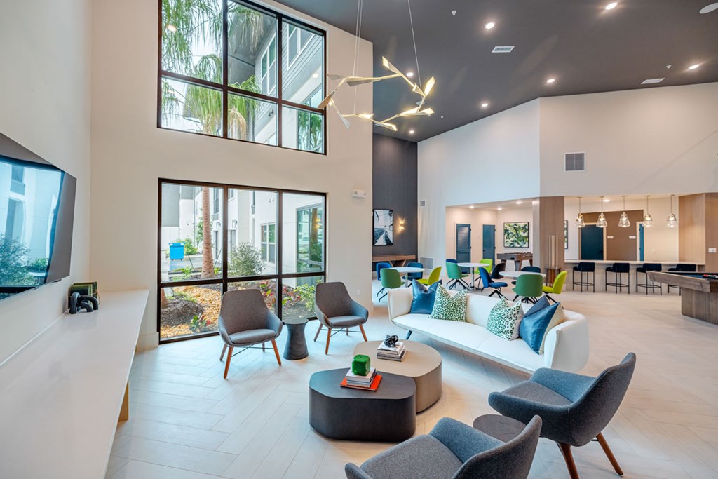 A modern living room with a large window and a view of trees.