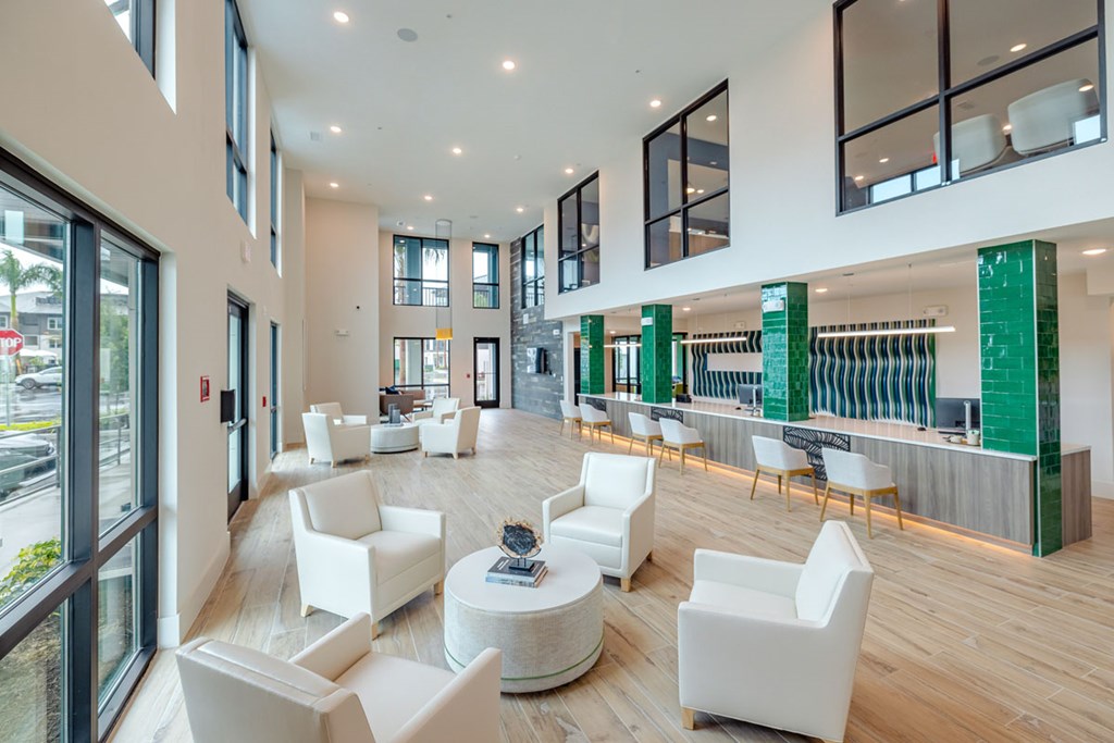 A spacious waiting area with white chairs and a green bar.