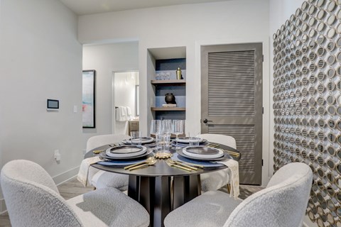 A modern dining room with a round table set for four.
