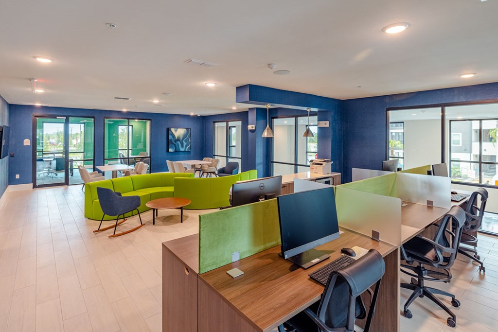 A modern office with blue walls and wooden desks.