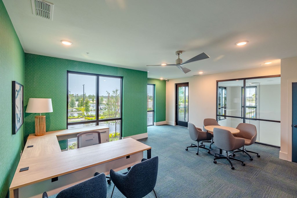 A room with a table and chairs and a ceiling fan.