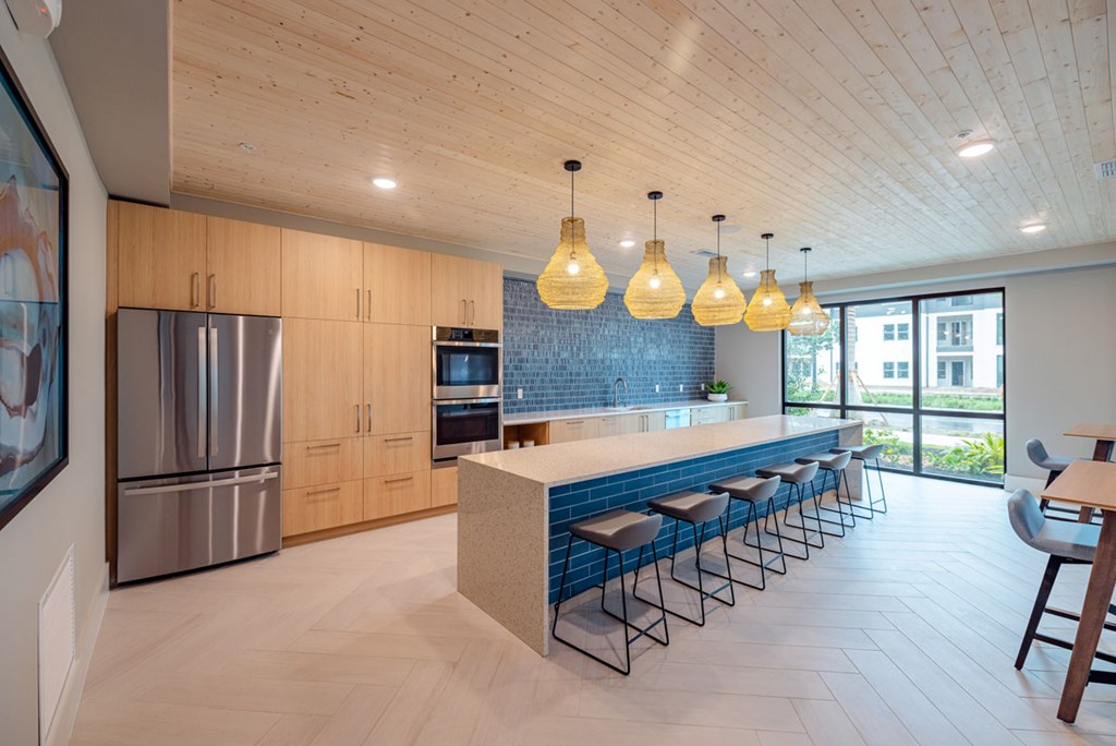 A kitchen with a long island and bar stools.