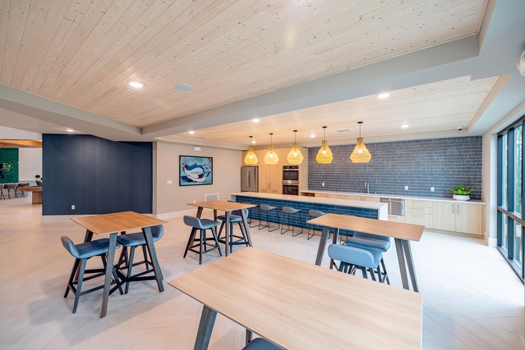 A modern dining area with wooden tables and blue chairs.