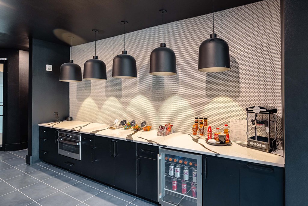 A modern kitchen with a white countertop and black cabinets.