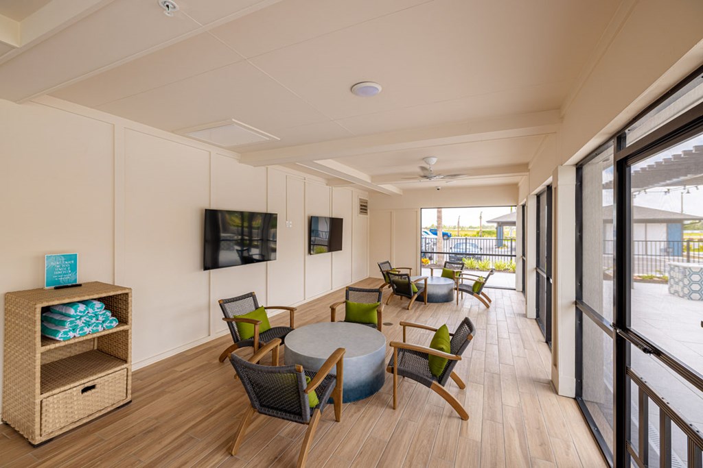 A room with a table and chairs and a TV on the wall.
