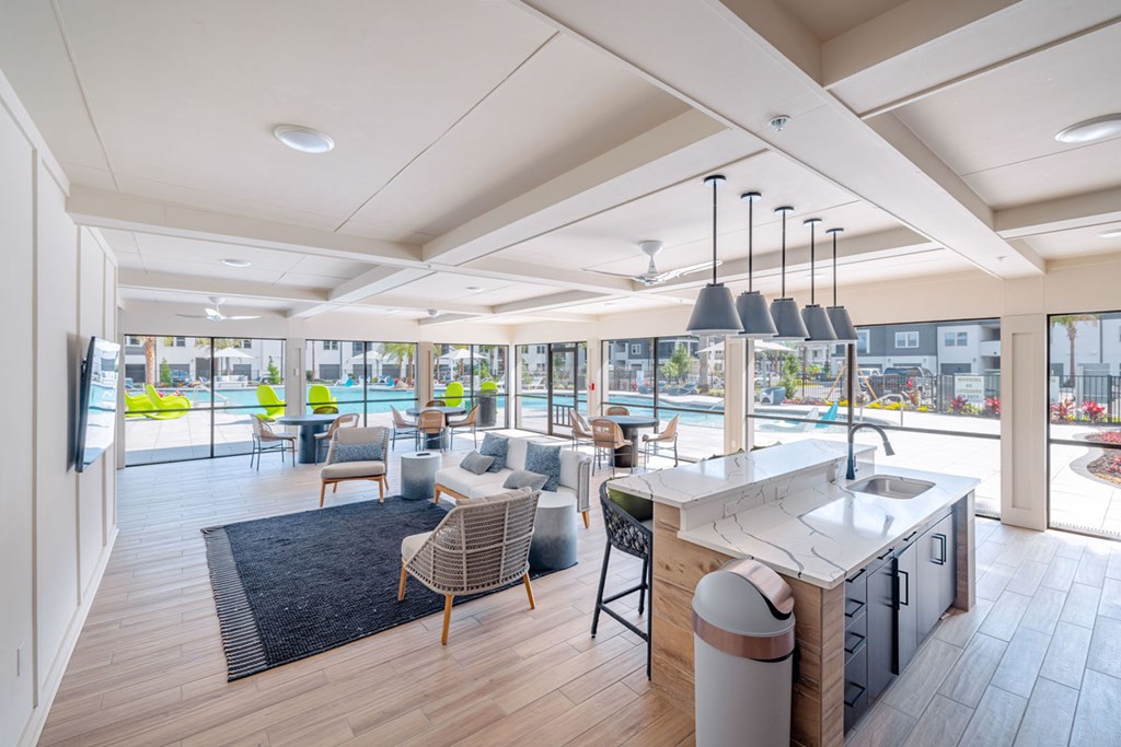 A modern kitchen with a large island and a view of the pool outside.