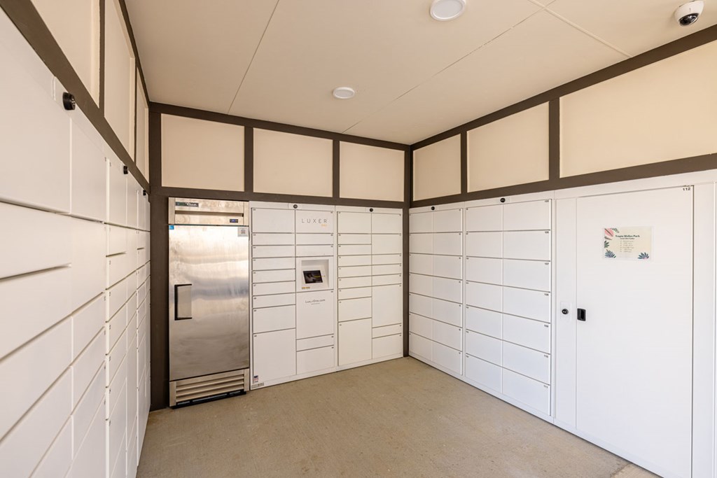 A kitchen with white cabinets and a stainless steel refrigerator.