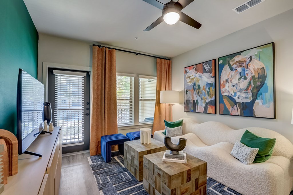 A living room with a white couch, a wooden coffee table, and a painting on the wall.