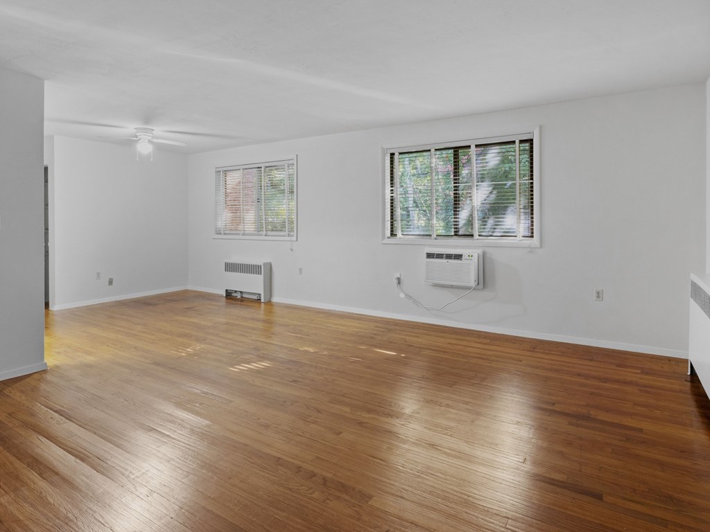 A room with wooden floors and two windows.