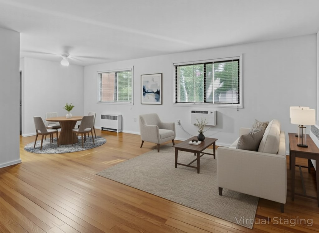 A living room with a white couch, a wooden coffee table, and a rug.