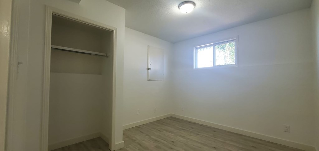 A room with a window and a closet.