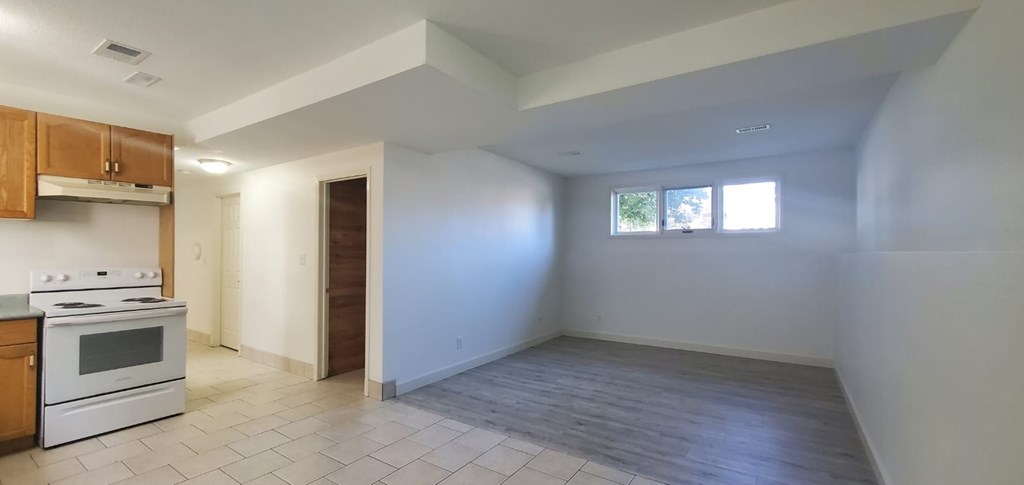 A kitchen with white appliances and wooden cabinets.