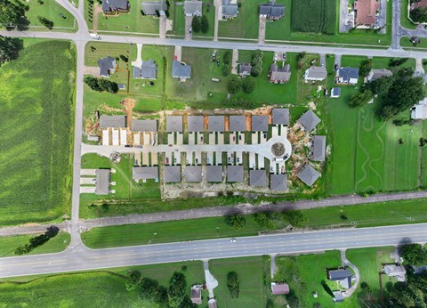 A long row of houses are lined up next to a road.