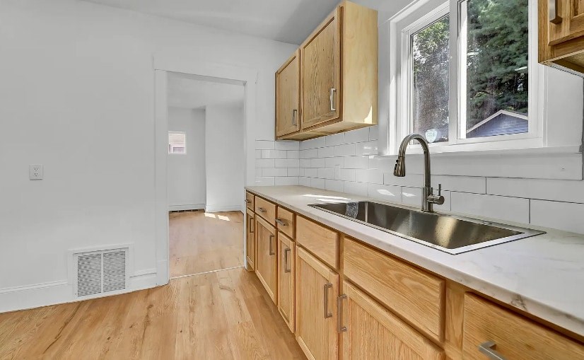 A kitchen with wooden cabinets and a white sink.