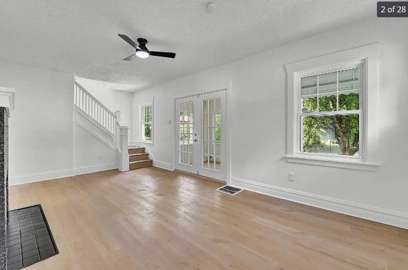 A spacious room with a staircase and a window.