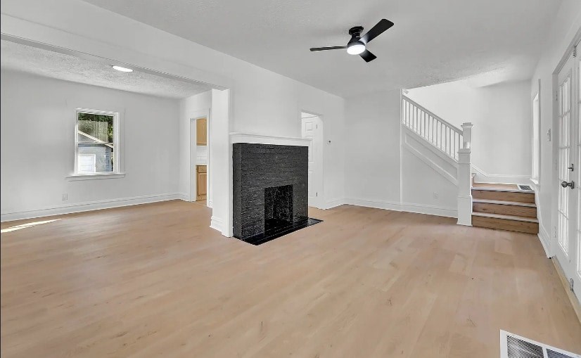 A living room with a fireplace and a staircase.