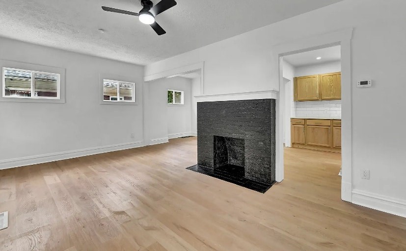 A living room with a fireplace and wood flooring.