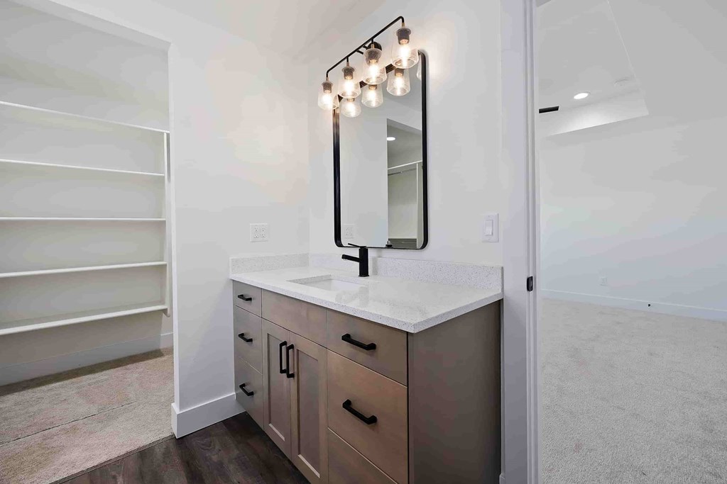 A bathroom vanity with a mirror and lights above it.