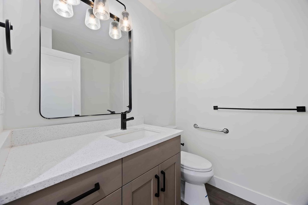 A bathroom with a white counter top and a white toilet.
