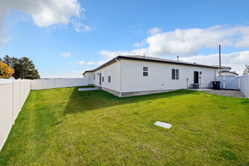 A white house with a green lawn in front.